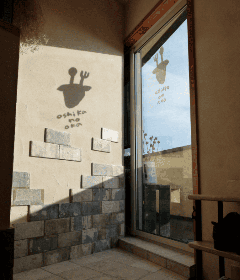 ヴィンテージ感あるレンガ・塗り壁・アイアンフレームの南欧風レストラン入口 ヴィンテージ感あるレンガ・塗り壁・アイアンフレームの南欧風レストラン入口